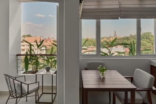 a dining room with a table and chairs and a window at Plantation Urban Resort & Spa in Phnom Penh