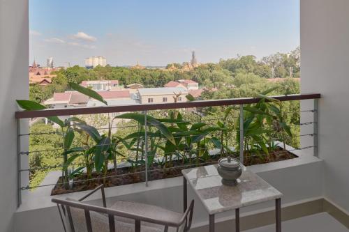 a balcony with a table and chairs and a view at Plantation Urban Resort & Spa in Phnom Penh