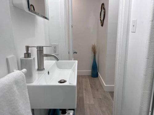 a white bathroom with a sink and a mirror at Cozy 1BR 1BA apt center of LA steps from the Grove in Los Angeles