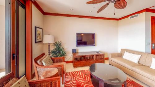 a living room with a couch and a tv at Ko Olina Beach Villas O401 in Kapolei