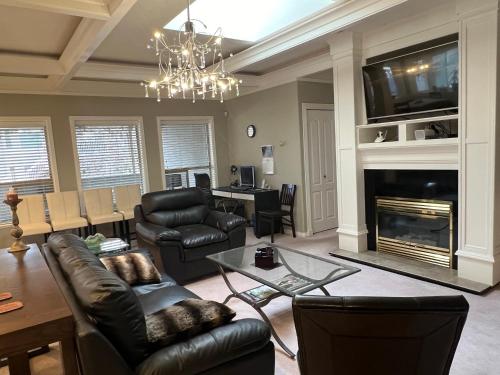 a living room with black leather furniture and a fireplace at V.I.P. CLUB in Surrey