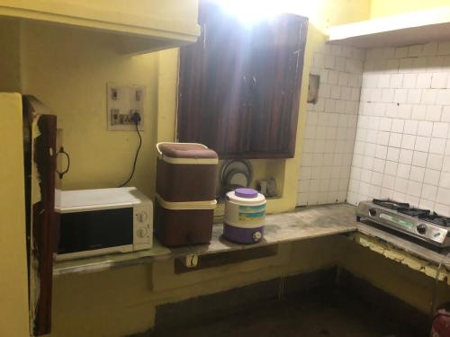 a small kitchen with a sink and a microwave at Private suite with living room in Kānpur
