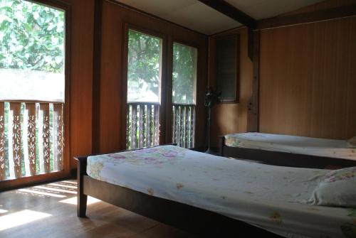 a bedroom with two beds and a balcony at Villa Guest House in Bangkok