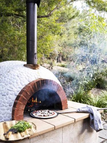 a pizza is cooking in a brick oven at Jamberoo Valley Farm in Jamberoo