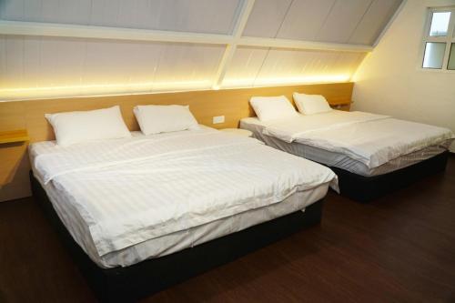 two beds in a small room with white sheets at Kesang Farm Jasin Melaka by I Housing in Jasin