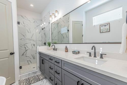 a bathroom with two sinks and a large mirror at Luxury Charming 3BR 3Bath Free Wi-FI 8 Guests, Gated Home, Houston Downtown in Houston