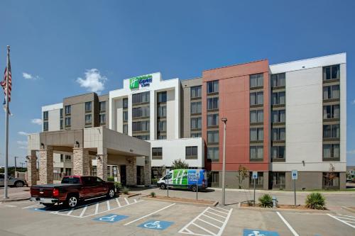 a hotel with a truck parked in a parking lot at Holiday Inn Express Hotel & Suites Dallas Fort Worth Airport South by IHG in Irving