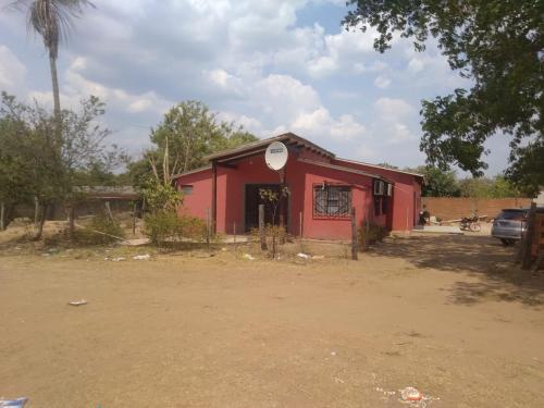 ein rotes Gebäude mit einem Basketballkorb darüber in der Unterkunft Casa San José in San José de Chiquitos