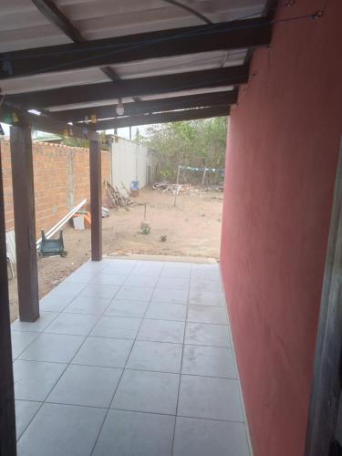 an empty garage with a red wall and tile floor at Casa San José in San José de Chiquitos