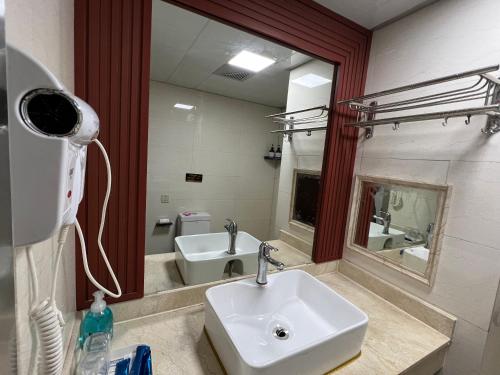bagno con lavandino e specchio di 张家界喜见客栈 a Zhangjiajie