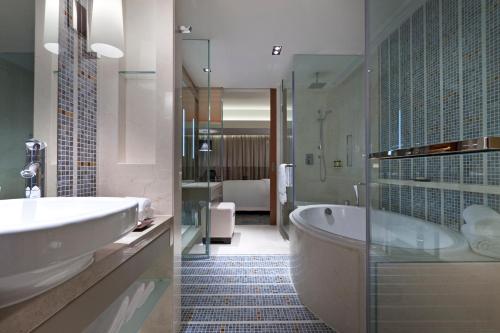 y baño con bañera, lavamanos y ducha. en Sheraton Grand Beijing Dongcheng Hotel, en Beijing