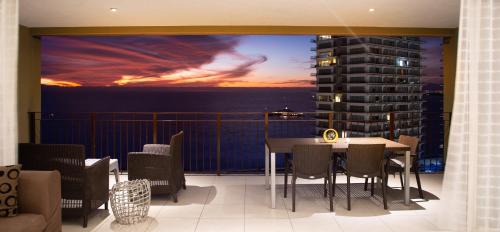 a room with a balcony with a table and chairs at Gorgeous 15 Floor Grand Venetian in Puerto Vallarta