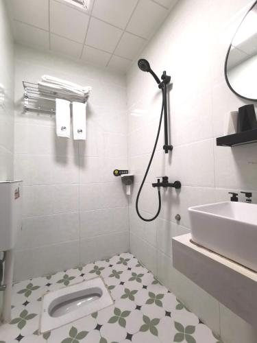 a white bathroom with a toilet and a sink at Yangshuo Jing Yuan Inn Near The West Street in Yangshuo