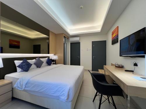 a bedroom with a bed and a desk and a computer at QUINCE HOME GRAND ION DELEMEN GENTING HIGHLANDs in Genting Highlands