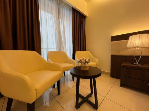 a hotel room with two chairs and a table at QUINCE HOME GRAND ION DELEMEN GENTING HIGHLANDs in Genting Highlands