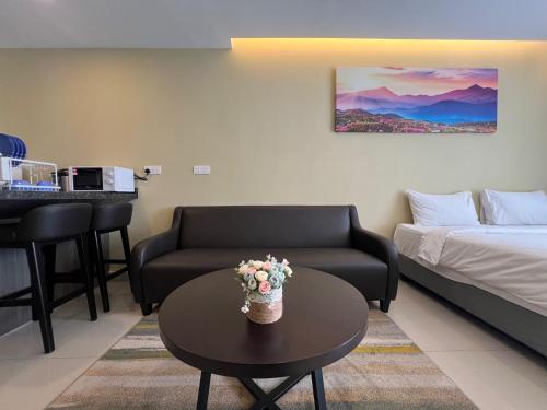 a living room with a couch and a table with flowers on it at QUINCE HOME GRAND ION DELEMEN GENTING HIGHLANDs in Genting Highlands