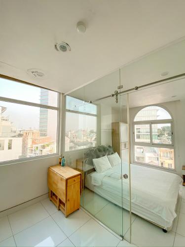 a bedroom with a bed and a glass shower at Aloha House Apartment in Ho Chi Minh City