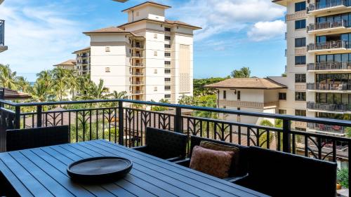 a table on a balcony with a view of a building at Ko Olina Beach Villas O521 in Kapolei