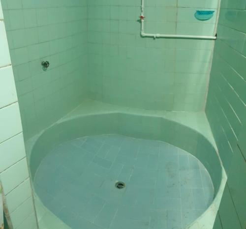 a white bath tub in a white tiled bathroom at Hostal Perla Del Norte in Murillo