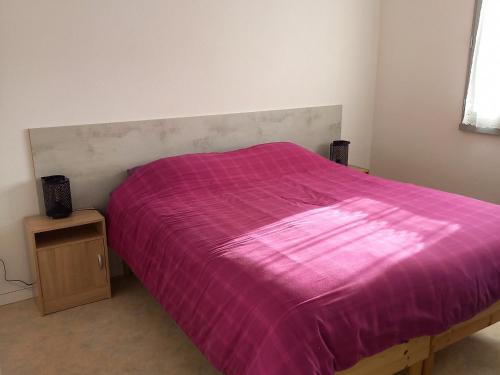 - un lit avec une couverture violette dans l'établissement Maison rénovée 2 chambres, proche forêt, terrasse, Saint Jean de Monts - FR-1-323-244, à Saint-Jean-de-Monts