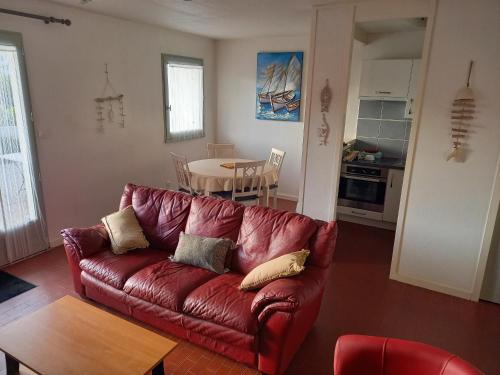 un salon avec un canapé rouge et une table dans l'établissement Maison rénovée 2 chambres, proche forêt, terrasse, Saint Jean de Monts - FR-1-323-244, à Saint-Jean-de-Monts