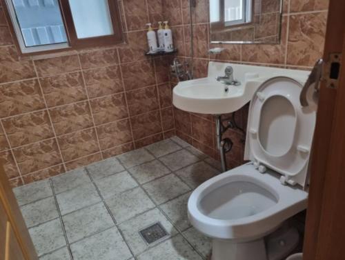 a bathroom with a toilet and a sink at Oreum Motel in Jeju