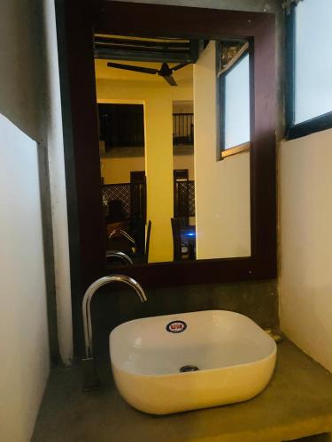 a bathroom with a sink and a mirror at Bienvenido Cozy Madiha in Matara