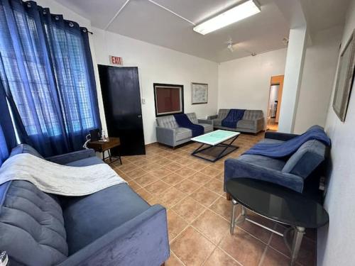 una sala de estar con sofás azules y una mesa. en Newly remodeled 3 BR Center Mayagüez, First Floor Unit1, en Mayagüez