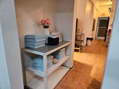 ein Schrank mit einem Regal mit Handtüchern und einer Vase mit Blumen in der Unterkunft Newly remodeled 3 BR Center Mayagüez, First Floor Unit1 in Mayaguez