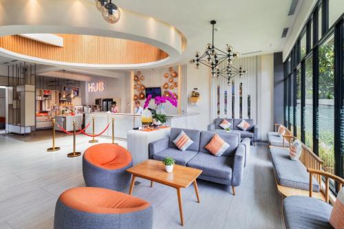 a lobby with couches and chairs and a table at HARRIS Hotel Kuta Tuban Bali in Kuta