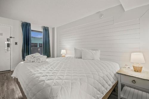 a white bedroom with a large bed and a window at 441 Landmark Resort in Myrtle Beach