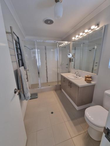 La salle de bains est pourvue de toilettes, d'un lavabo et d'une douche. dans l'établissement The White House, à Geographe