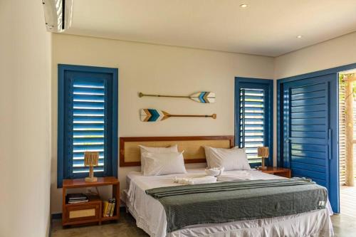 a bedroom with blue shuttered windows and a large bed at Casa de Praia Perfeita in Fortim