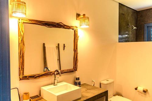 a bathroom with a sink and a mirror and a toilet at Casa de Praia Perfeita in Fortim