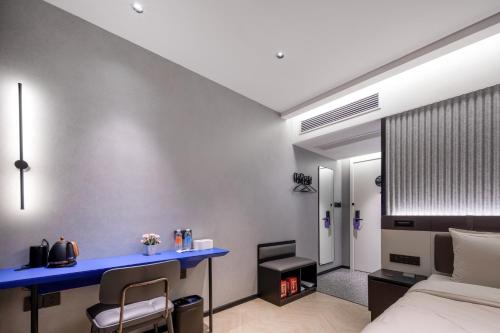 a bedroom with a bed and a desk and a fireplace at Atour Light Hotel Zhoushan Dinghai South Renmin Road in Zhoushan