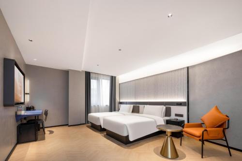 a bedroom with a bed and a table and a chair at Atour Light Hotel Zhoushan Dinghai South Renmin Road in Zhoushan