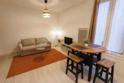 ein Wohnzimmer mit Sofa und Tisch in der Unterkunft Lafra 2 - Chaleureux & Intime - Mon Groom in Troyes