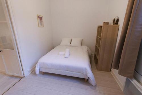 Cette petite chambre comprend un lit avec des draps blancs. dans l'établissement Lafra 2 - Chaleureux & Intime - Mon Groom, à Troyes