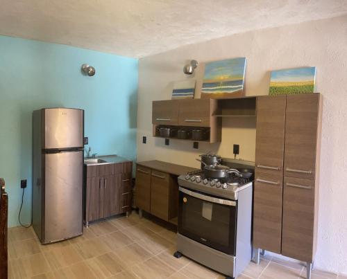 a kitchen with a stove and a refrigerator at CASA RAQUEL in Rincon de Guayabitos