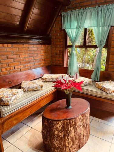 Zimmer mit 2 Betten und einem Tisch mit einer Blumenvase in der Unterkunft Morro Azul chalés in Timbó