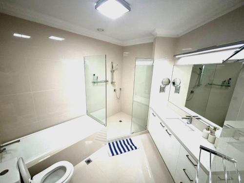 uma casa de banho com um chuveiro, um lavatório e um WC. em Royal Albert Hotel em Brisbane