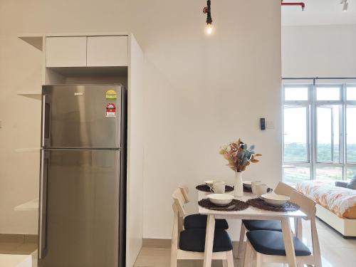 eine Küche mit einem Kühlschrank und einem Tisch mit Stühlen in der Unterkunft Mount Austin 6pax hastamas wifi500mps nexflix in Johor Bahru