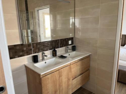 une salle de bain avec un lavabo et un miroir dans l'établissement Villa pieds dans l'eau, 4 pers, 2 chambres, terrasse, parking, plage directe, Grau d'Agde - FR-1-749-39, au Grau-dʼAgde