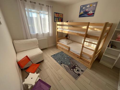 Cette petite chambre comprend des lits superposés et un canapé. dans l'établissement Maison familiale avec jardin, proche Dune du Pyla - 3 chambres - TV, WiFi, parking - FR-1-319-536, à Gujan-Mestras