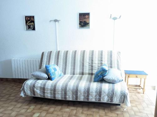 un sofá en una sala de estar con almohadas en Appartement Marseillan-Plage, 2 pièces, 4 personnes - FR-1-387-202, en Marseillan