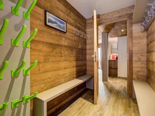 Cette chambre est dotée d'un mur en bois avec un banc. dans l'établissement Chalet confortable au centre - 10 pers, animaux admis, WiFi gratuit - FR-1-181-2795, à La Plagne Tarentaise