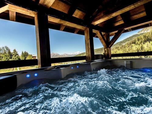 une baignoire jacuzzi avec vue sur les montagnes dans l'établissement Chalet de charme avec jacuzzi, sauna et wifi, proche des pistes - FR-1-181-2797, à La Plagne Tarentaise