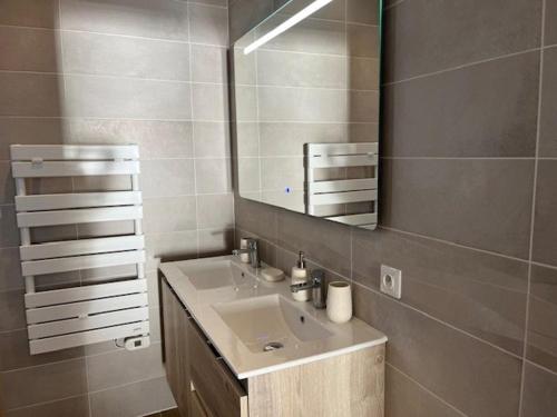 une salle de bain avec un lavabo et un miroir dans l'établissement Villa 2 chambres au bord de mer avec accès direct plage, terrasse et parking privé - Grau d'Agde - FR-1-749-40, au Grau-dʼAgde