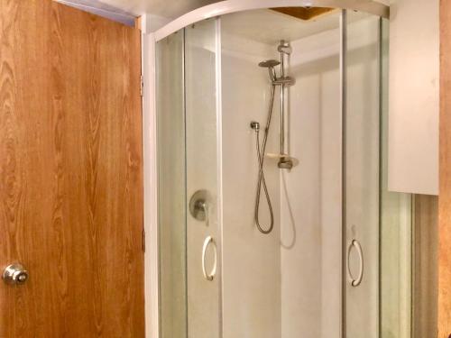 a shower with a glass door in a bathroom at Unique and Charming Garden Cottage/Campervan in Rangataua