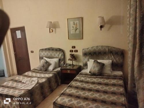 a hotel room with two beds and a table at Anubis Hostel in Cairo